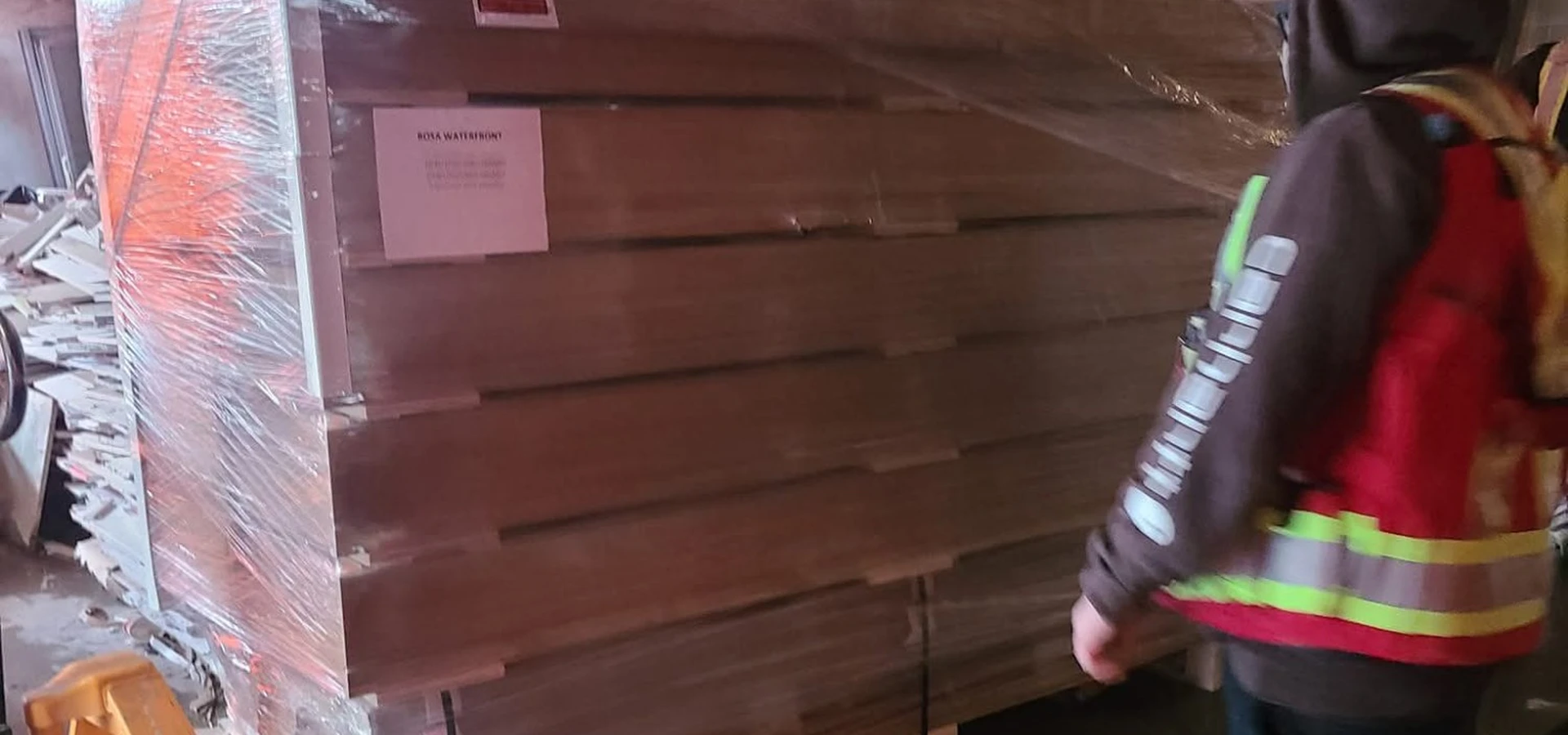 Gorilla Moves commercial mover in hard hat and safety vest moving a wrapped pallet in an industrial space